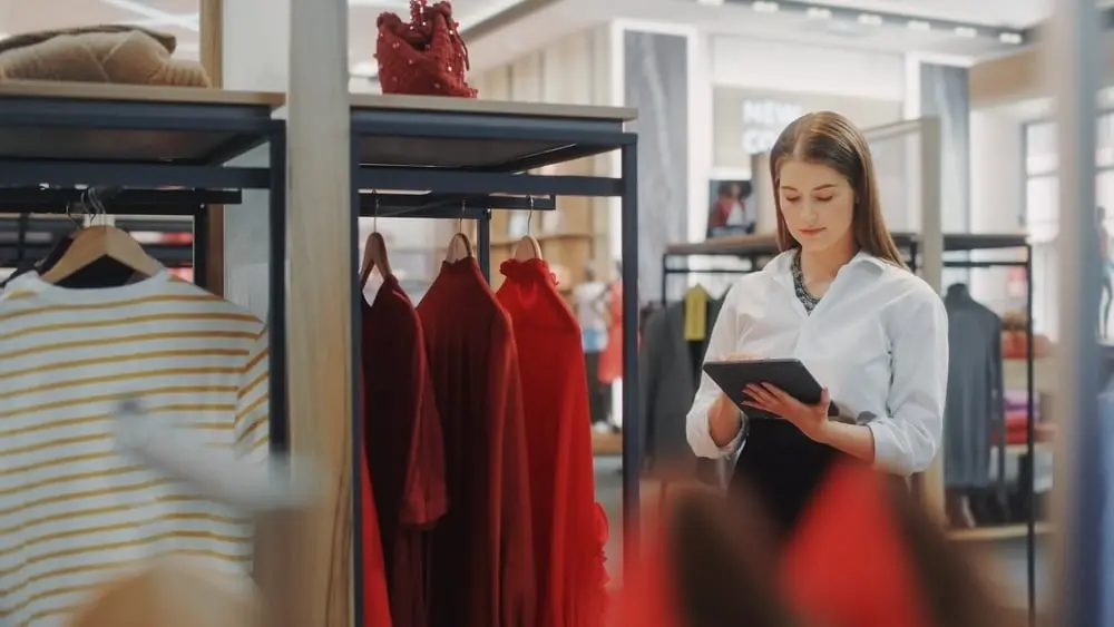 woman checking inventory on tablet in boutique