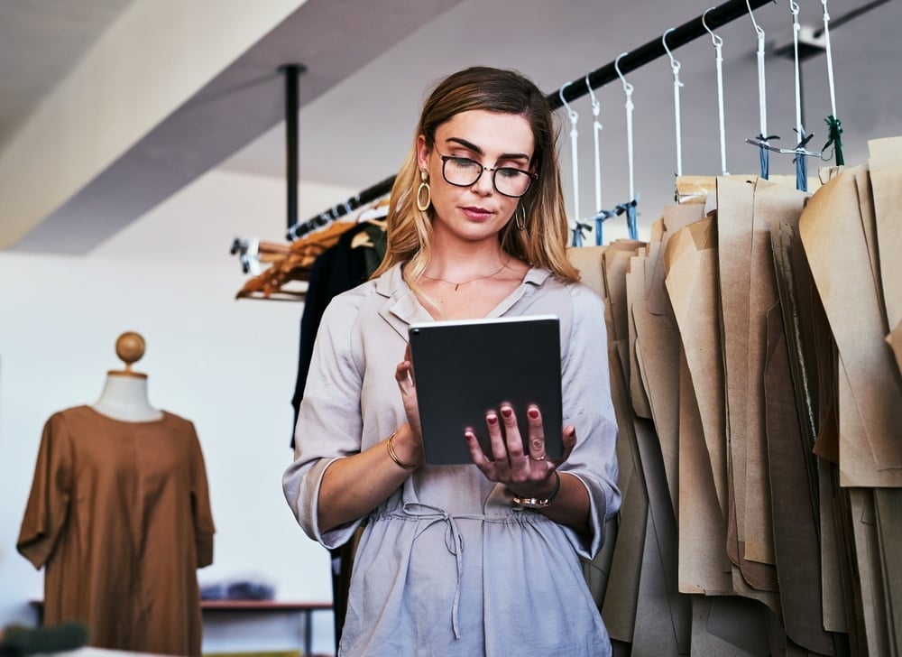 woman holding tablet working in boutique